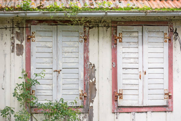 Windows with window shutters of an decayed house.