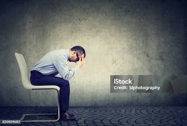 Sad Stressed Businessman Sitting In An Empty Office Stock Photo - Download Image Now