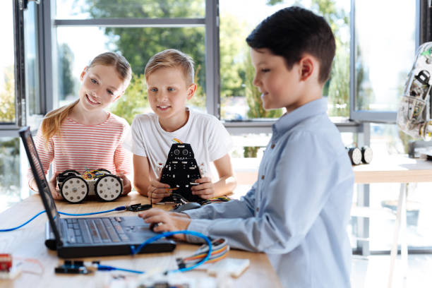 istock Boy and girl watching their friend work on laptop 820862940