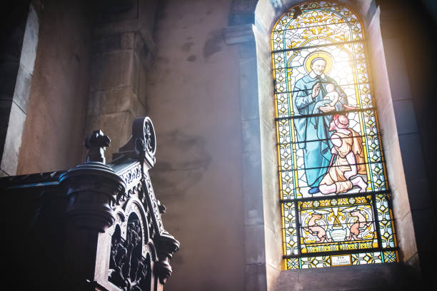 primer plano de hermosa cristiana transparente vidriera de la iglesia francesa de trévoux ciudad de interior con luz del sol - christianity church indoors illuminated fotografías e imágenes de stock