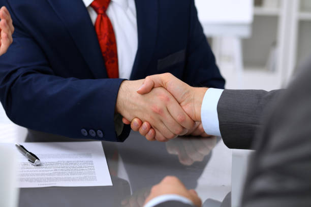 istock Two business man shaking hands to each other above signed contract 820863730