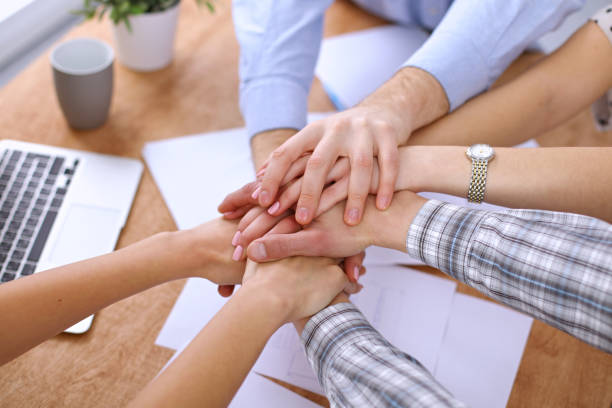 istock Business people joining hands over table 820864934