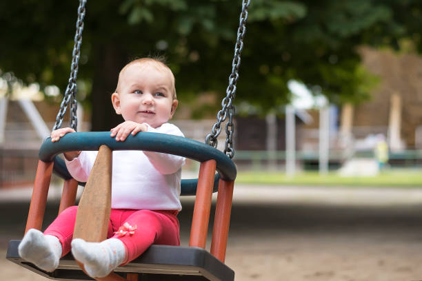 istock small active child happily swings on a swing in a summer park. 820865064