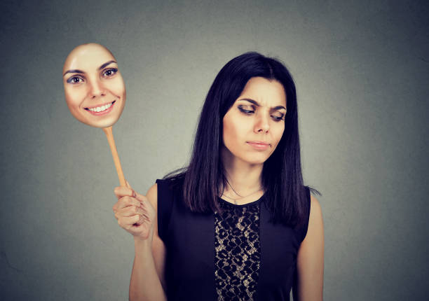 istock woman with sad expression taking of a mask expressing cheerfulness 820865756