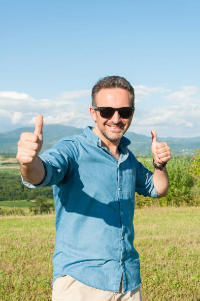 istock Cheerful handsome guy outside showing thumbs up 820865792