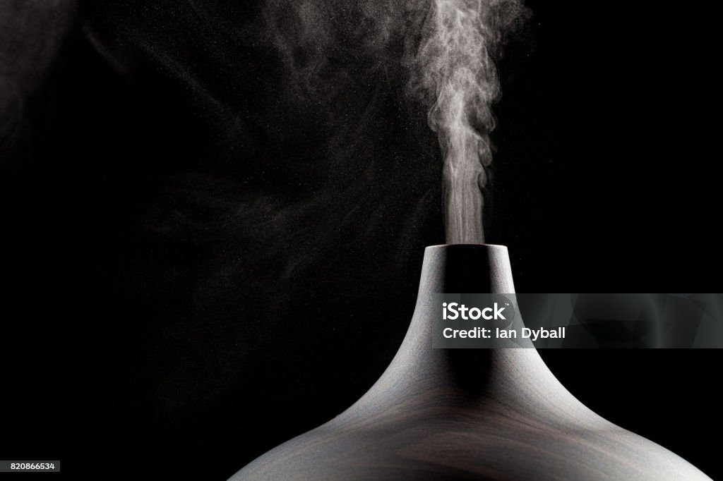 Close up of an ultrasonic aromatherapy oil diffuser in use. Close up of an ultrasonic aromatherapy oil diffuser in use. Atomized water droplets being dispensed into the air. Humidifier Stock Photo