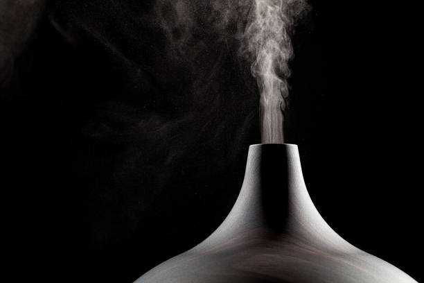 Close up of an ultrasonic aromatherapy oil diffuser in use. Close up of an ultrasonic aromatherapy oil diffuser in use. Atomized water droplets being dispensed into the air. ian stock pictures, royalty-free photos & images