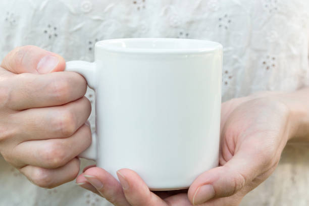istock Young caucasian woman holding a white mug, mock up, blank space for text, artwork, hands, linen shirt, natural authentic, kinfolk style 820866840