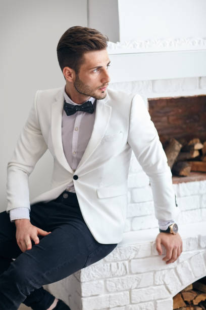 istock Handsome stylish man in elegant suit sitting near fireplace 820866900