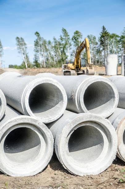 istock Construction site with concrete pipes in foreground and excavator during summer day 820866948