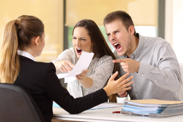 Angry couple claiming at office Angry couple claiming and shouting to an office worker Displeased stock pictures, royalty-free photos & images