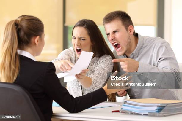 Angry Couple Claiming At Office Stock Photo - Download Image Now - Customer, Anger, Displeased