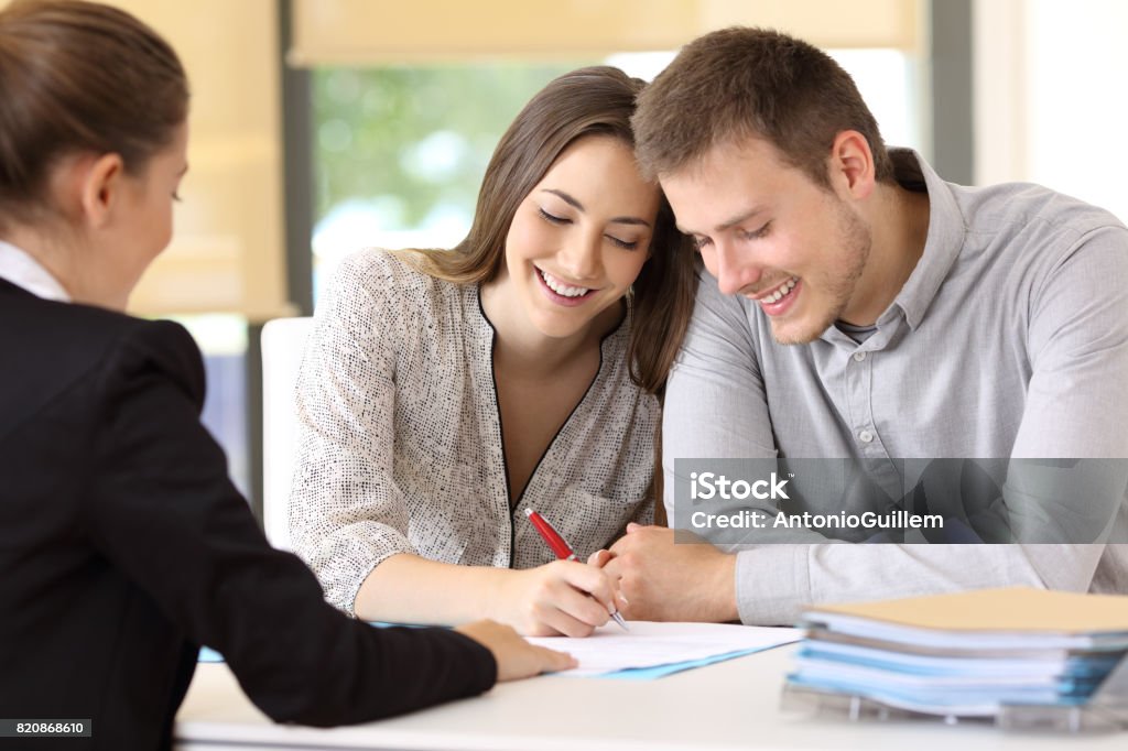 Glückliches Paar, die Unterzeichnung eines Vertrages im Büro - Lizenzfrei Unterschreiben Stock-Foto