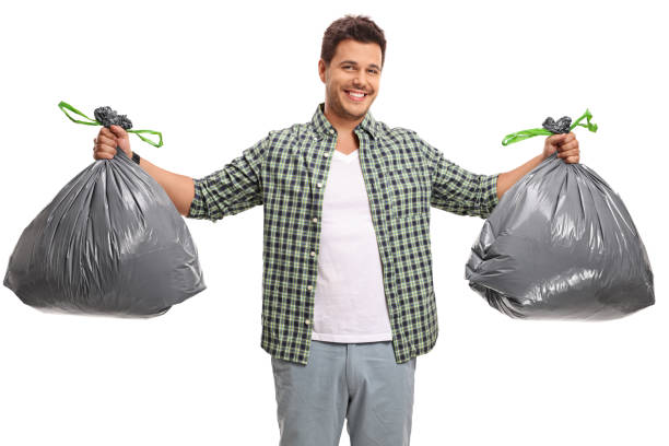 Young guy with two bags of garbage isolated on white background