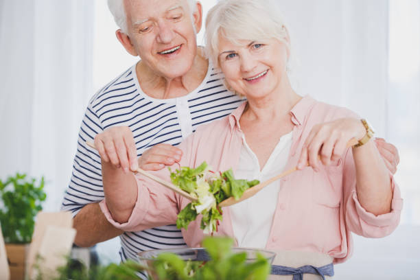 istock Elder woman and man preparing salad 820869620