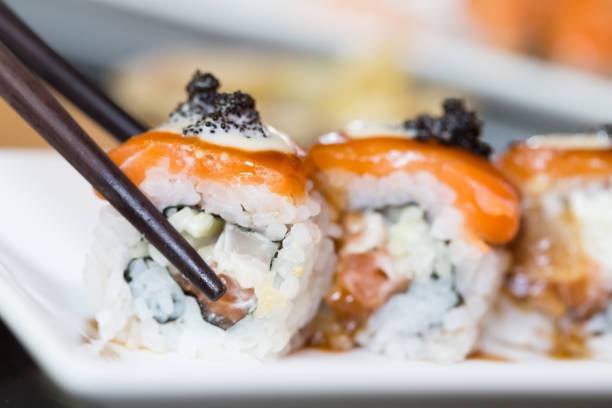 istock Sushi roll and black chopsticks 820871970