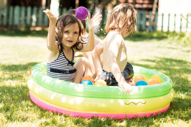 istock Cute children having fun in swimming pool 820872246