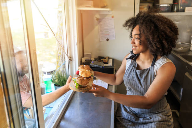 Food van chef serving sandwiches to customer Food van chef serving sandwiches to customer. High angle view. spanish hamburger stock pictures, royalty-free photos & images