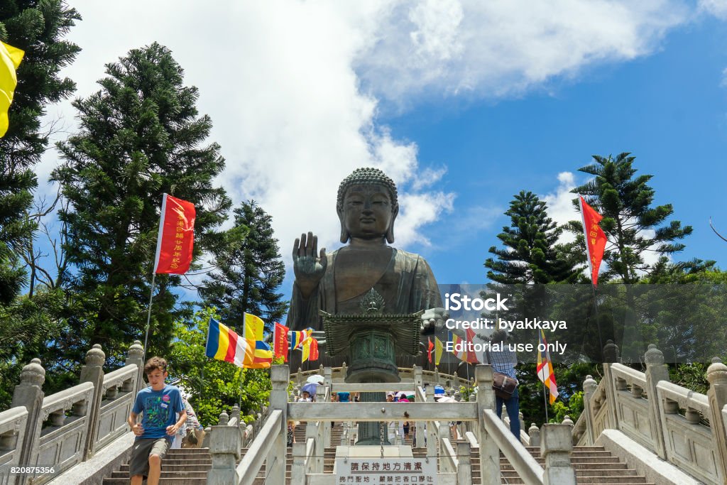Chinese tourists at giant Buddha Hong Kong Scene Of Tian Tan Buddha Also Known As The Big Buddha Situated At Lantau Island Hong Kong China East Asia.Including People Looking Around,Taking Pictures,Talking To One Another,Climbing Steps,Walking Down Steps On A Beautiful Day 2017 Stock Photo