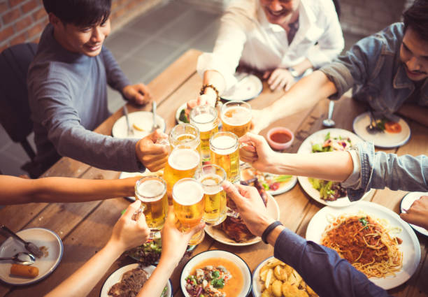 le persone asiatiche stanno celebrando il festival che sbatteno i bicchieri birra e cena happy.top vista - irish culture beer drinking pub foto e immagini stock