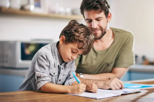 Shot of a single father helping his son with his homework