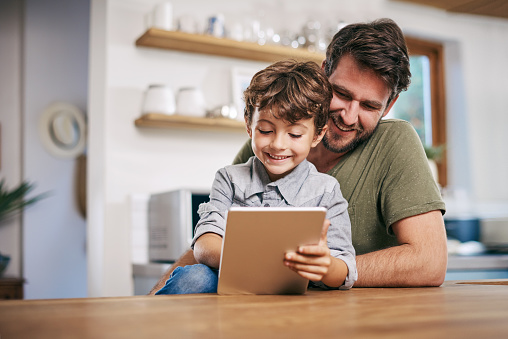 Shot of a single father sitting with his son while using a digital tablet