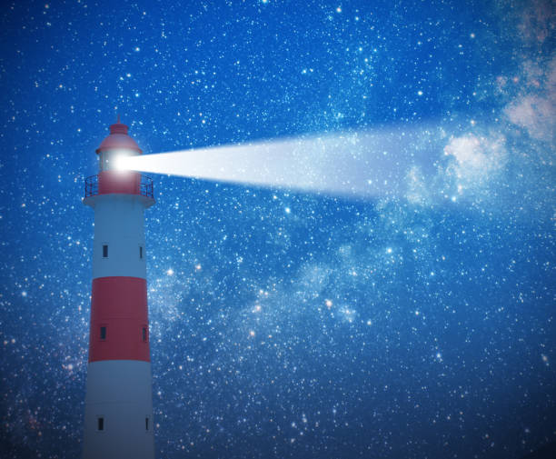 phare en action avec faisceau et ciel étoilé - dark light beam beacon projection photos et images de collection