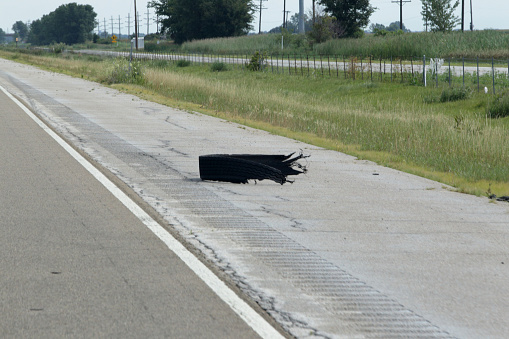 Una pieza de un neumático destrozado se encuentra en el hombro de la interestatal 55.  Más allá de la valla es la 
