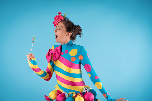 Beautiful young woman celebrating with  candy  in costume party