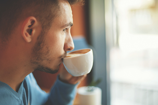 Close-up of young man enjoyment coffee.