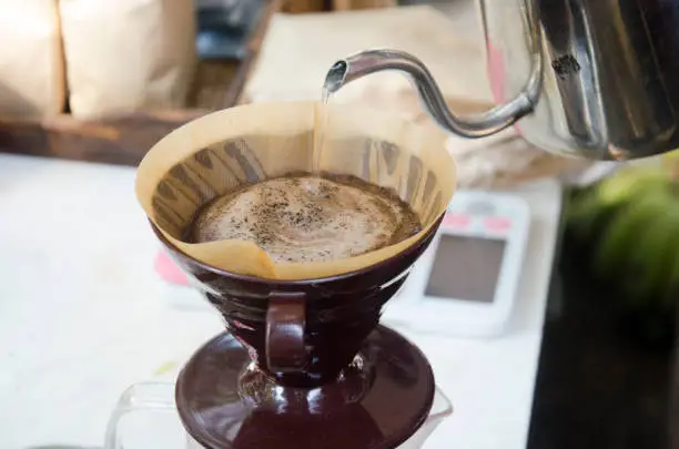 Thai people use drip coffee maker or dripper made hot coffee for sale for people at shop in organic market in Nakhon Ratchasima, Thailand