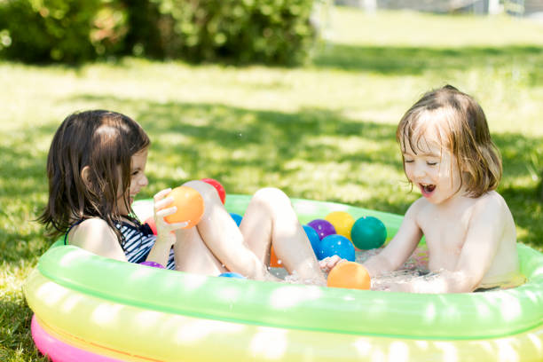 istock Cute children having fun in swimming pool 820912454