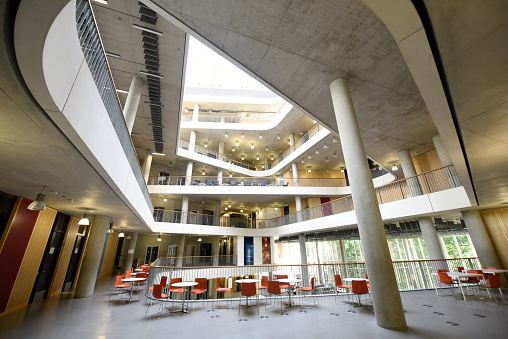 Interior showing stunning modern architecture, different floors from mezzanine to skylight inside atrium.