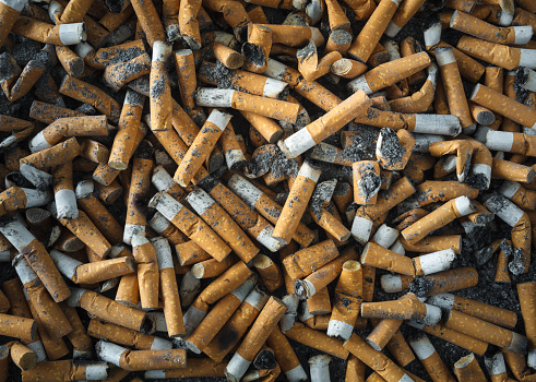 Closeup view of ashtray full of cigarette butts on the table