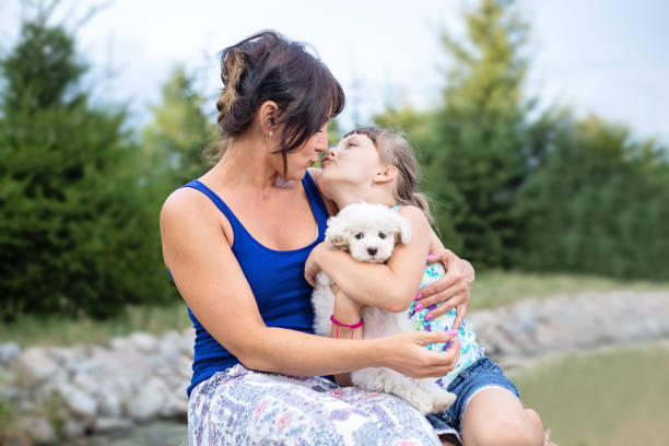 istock Mother and small daughet kissing outdoors in nature 820932900