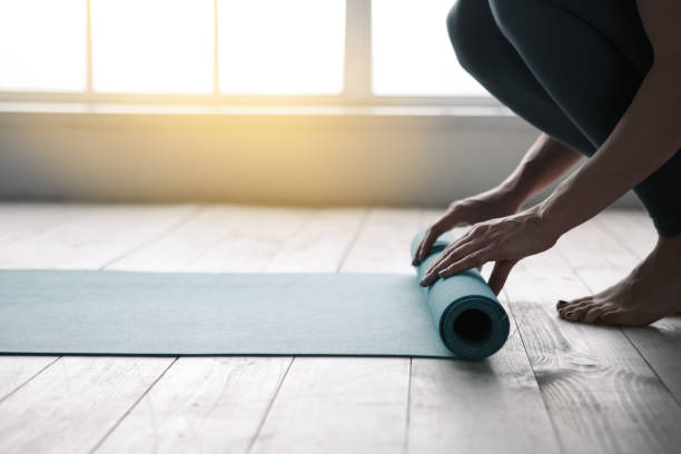 mujer joven haciendo yoga twist alfombra estilo de vida saludable - centro de yoga fotografías e imágenes de stock
