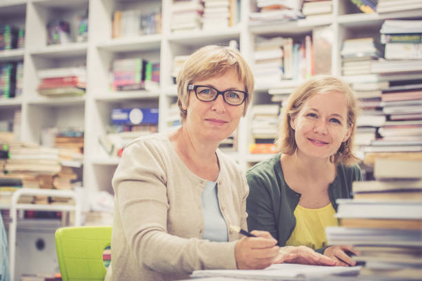 istock Two mature college women students studying at table in a new library 820945834