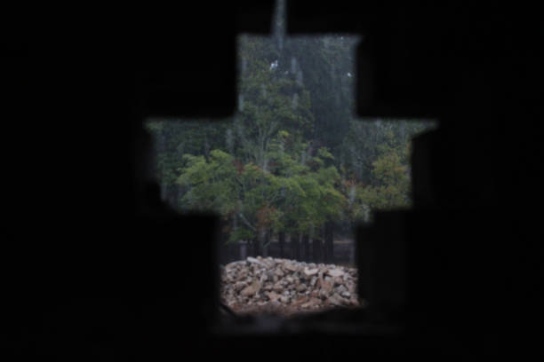 This is a picture of a patio and brick wall with a cut out in the shape of a cross or t-shape, with rain pouring down in the background, taken by Trey McGriff.