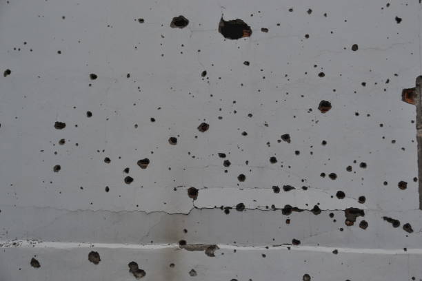 Gun bullet-riddle hole on the wall stock photo