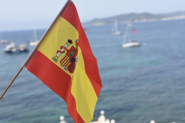 flagge von spanien am strand von ibiza - spain flag built structure cloud stock-fotos und bilder