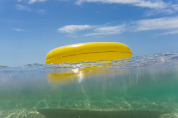 istock Yellow rubber ring floating on the sea, Pedn Vounder Beach 820968548
