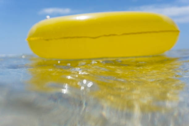 Yellow rubber ring floating on the sea, Pedn Vounder Beach