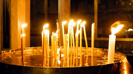 Burning candles in the Holy Sepulcher Church in Jerusalem. The Holy Sepulchre Church and Empty Tomb the most sacred places for all religious Christians in the world.