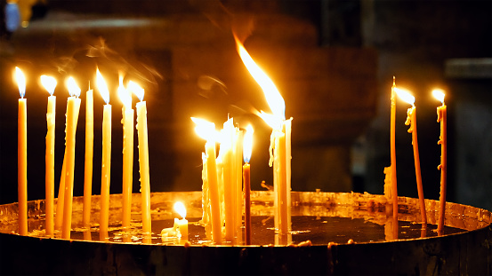 Burning candles in the Holy Sepulcher Church in Jerusalem. The Holy Sepulchre Church and Empty Tomb the most sacred places for all religious Christians in the world.