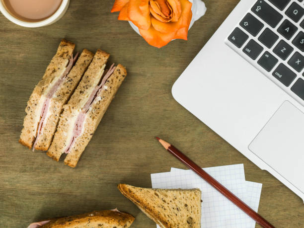 Ham and Cheese Sandwich in Brown Bread With a Cup of Tea At a Computer Workstation