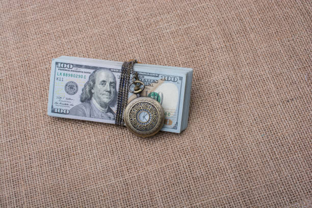 istock Pocket watch wrapped around US dollar 821002424