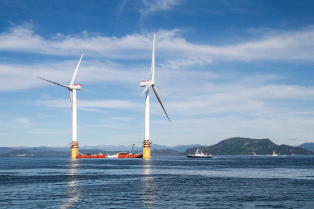 Stord, Norway-June 27, 2017: two of five floating wind turbines being prepared to sail off to the world's first floating wind farm Wind turbines assembled at Stord, Norway, under preparation to be sailed to the floating windmill farm, Hywind Scotland Pilot Park, near Peterhead, Scotland.  ballast water stock pictures, royalty-free photos & images