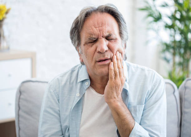 Old man with tooth sensitivity Old man with tooth sensitivity bad teeth stock pictures, royalty-free photos & images