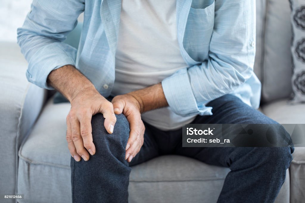 Vieil homme souffrant d’une douleur au genou - Photo de Douleur libre de droits