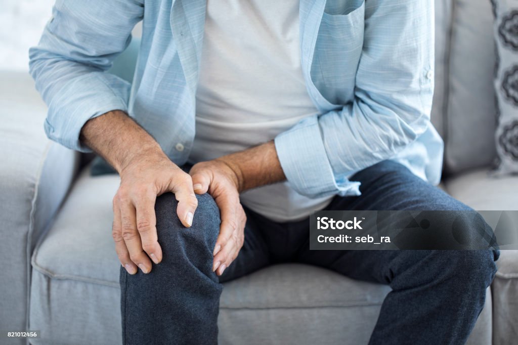 Old man suffering from knee pain Pain Stock Photo
